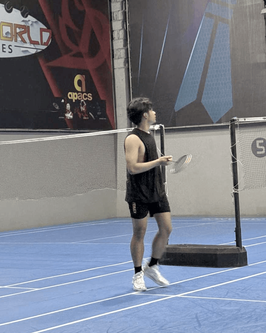 Mid-rally on a badminton court