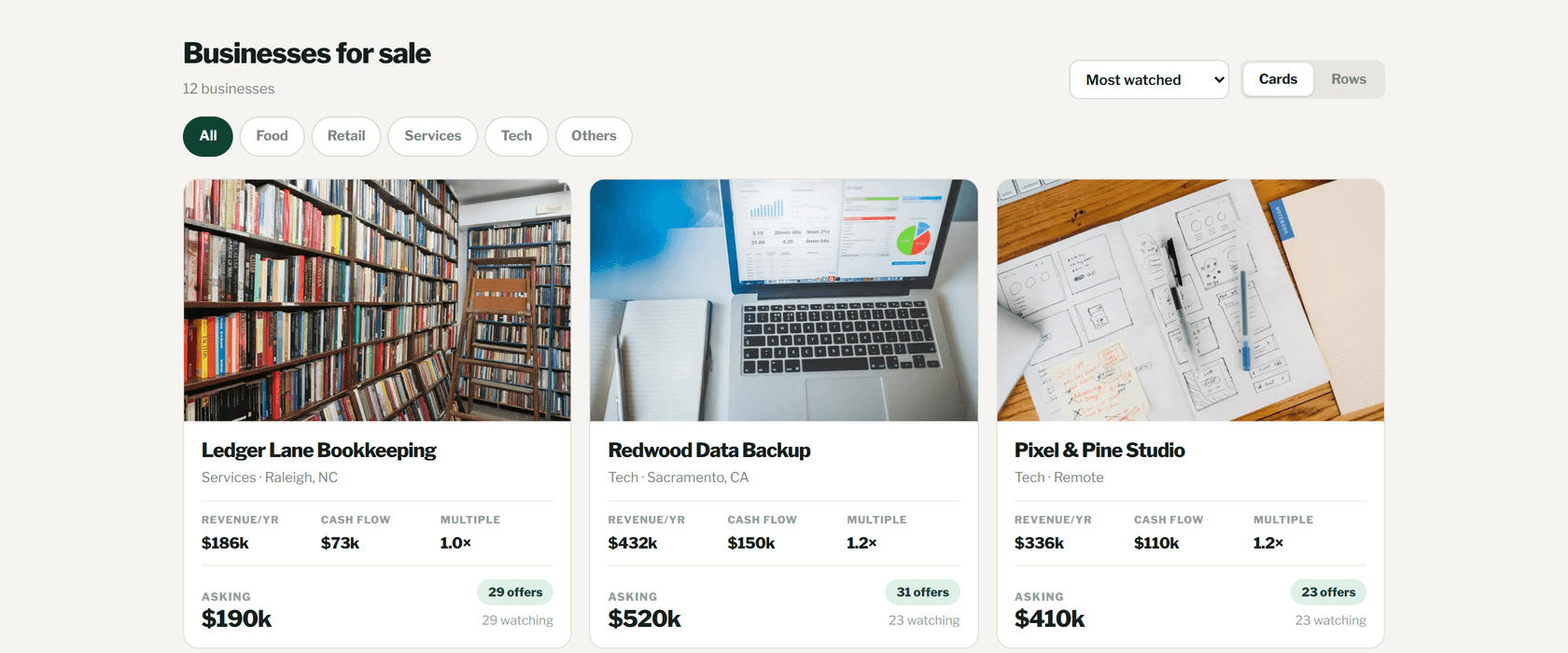 The ScoutBoard marketplace under the heading 'Businesses for sale': category filter chips, a sort dropdown and a cards/rows toggle above a grid of listing cards, each with a photograph, industry and city, yearly revenue, asking multiple, asking price and a live offer count.